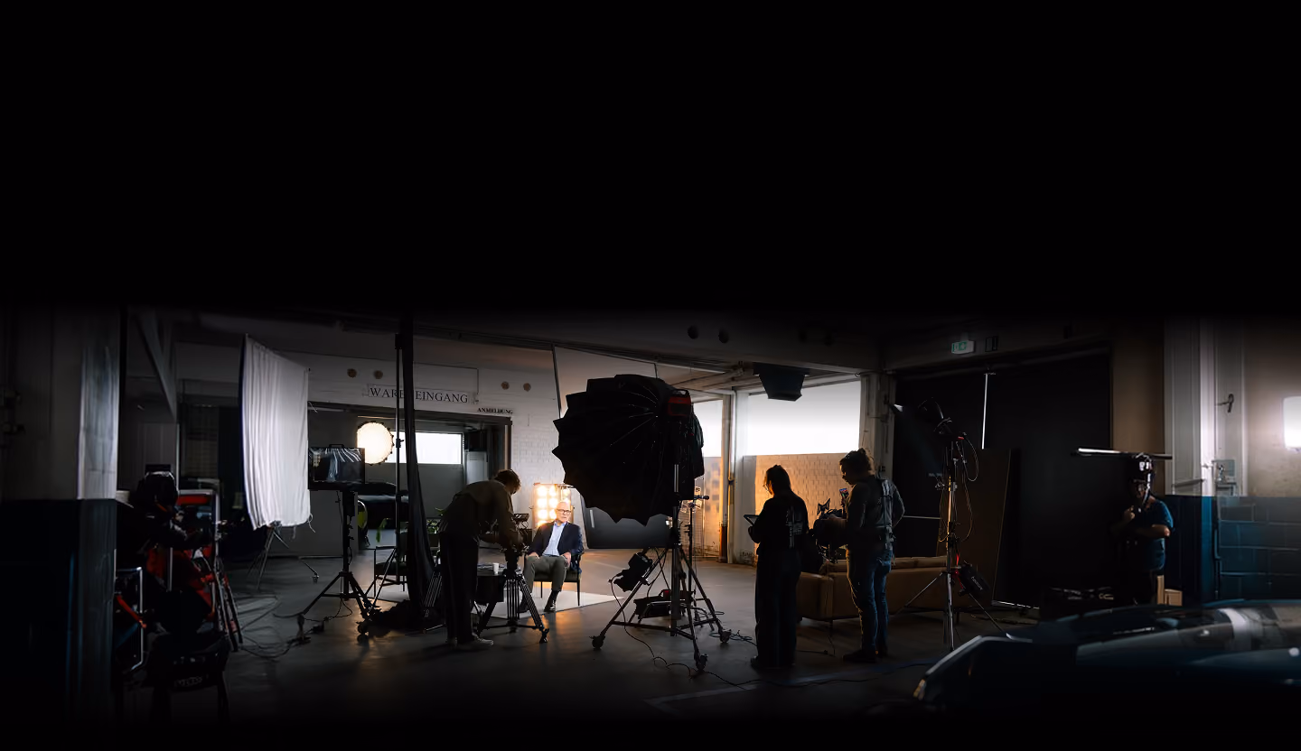 Film crew setting up lights and cameras for an interview shoot