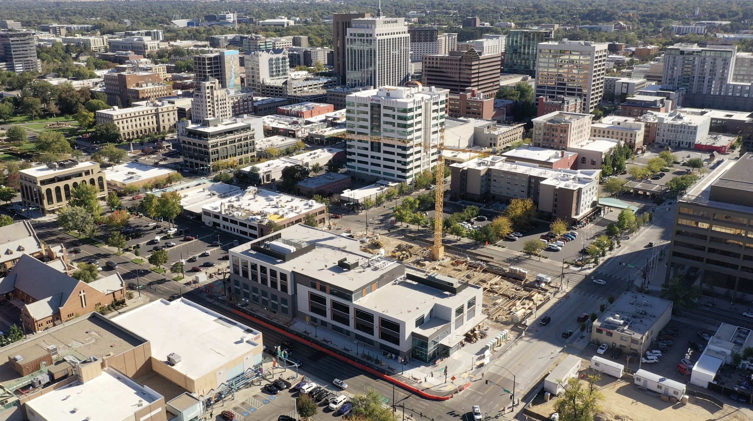 Aerial view of the new CapEd Downtown YMCA on State Street with the Boise skyline behind it