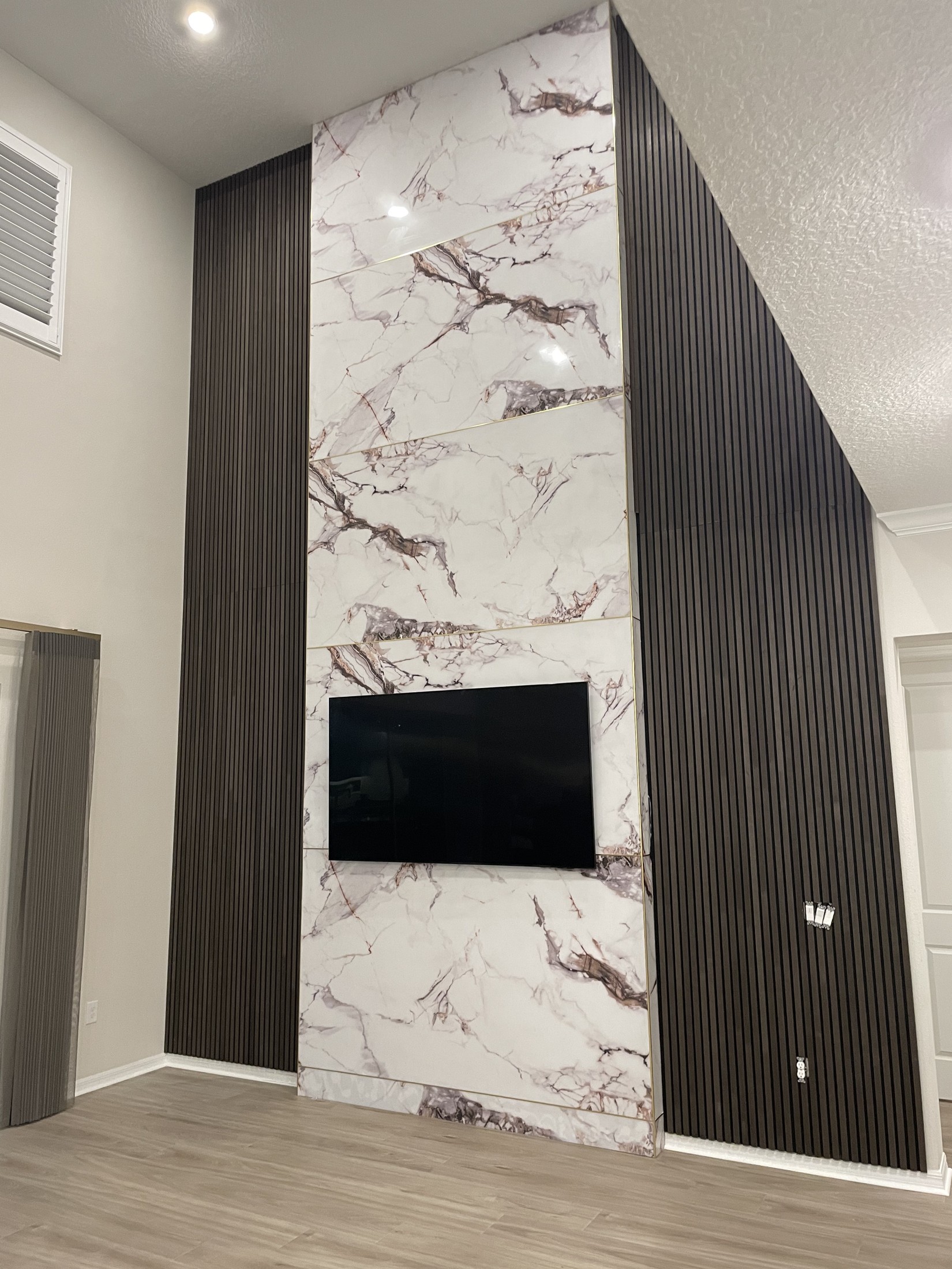 Media wall after the central finish and side slats were installed, before the shelves and base cabinetry were added