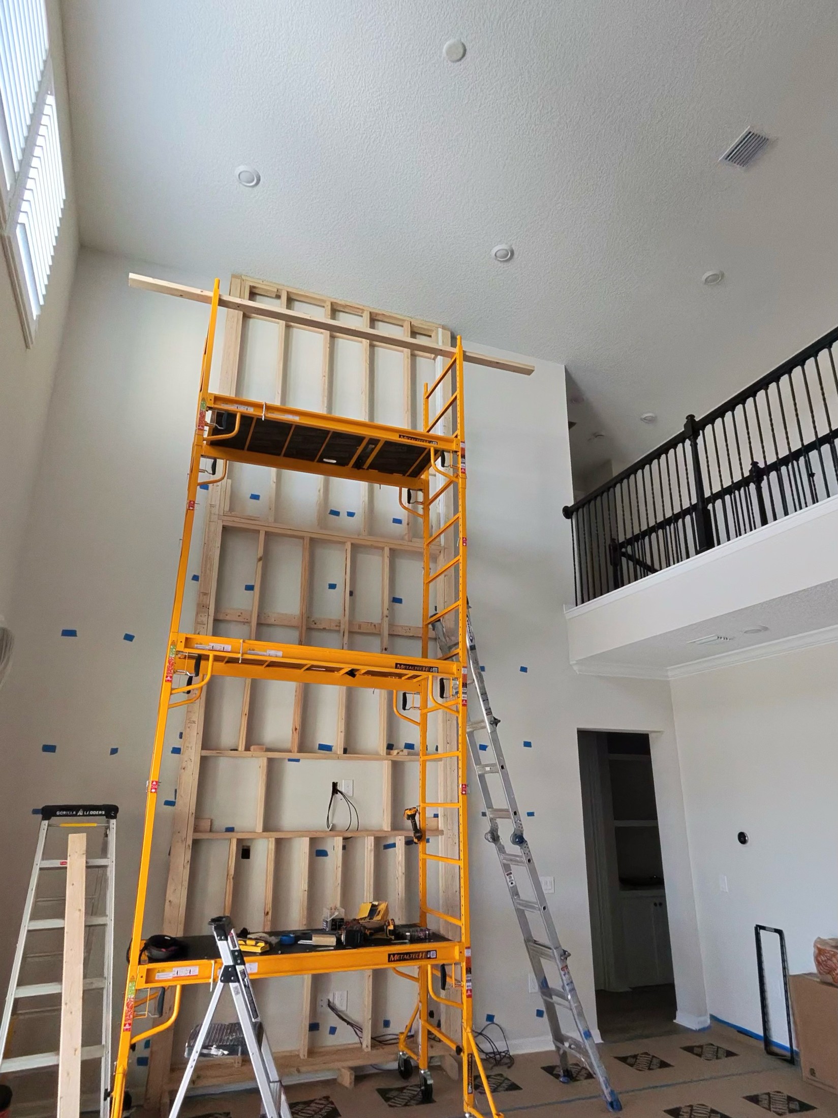 Timber framing for the tall central feature with access scaffolding in the living room