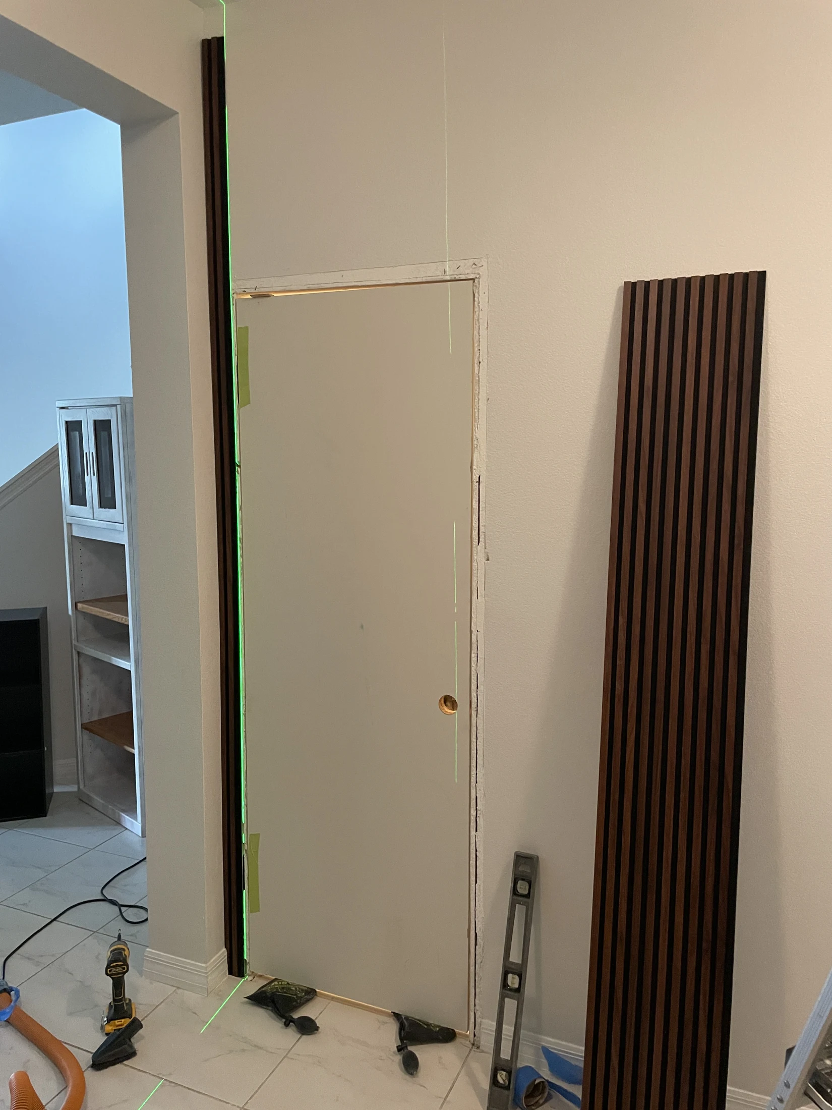 Unfinished door surface and adjacent slat panel during installation
