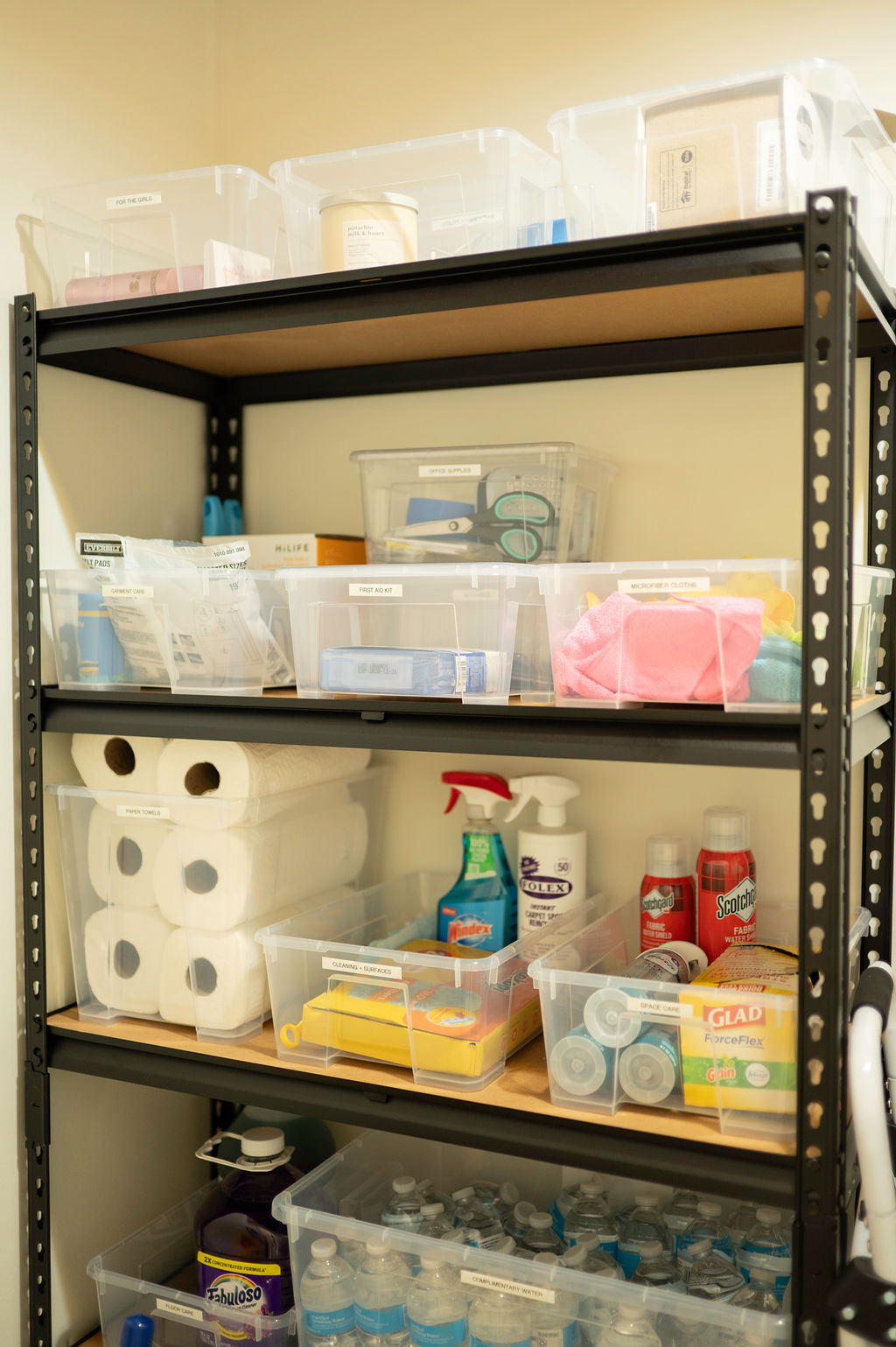 Stocked supply shelf with paper towels, cleaning supplies and water