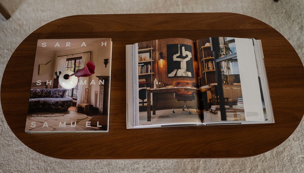 Coffee table books on a walnut table in the studio