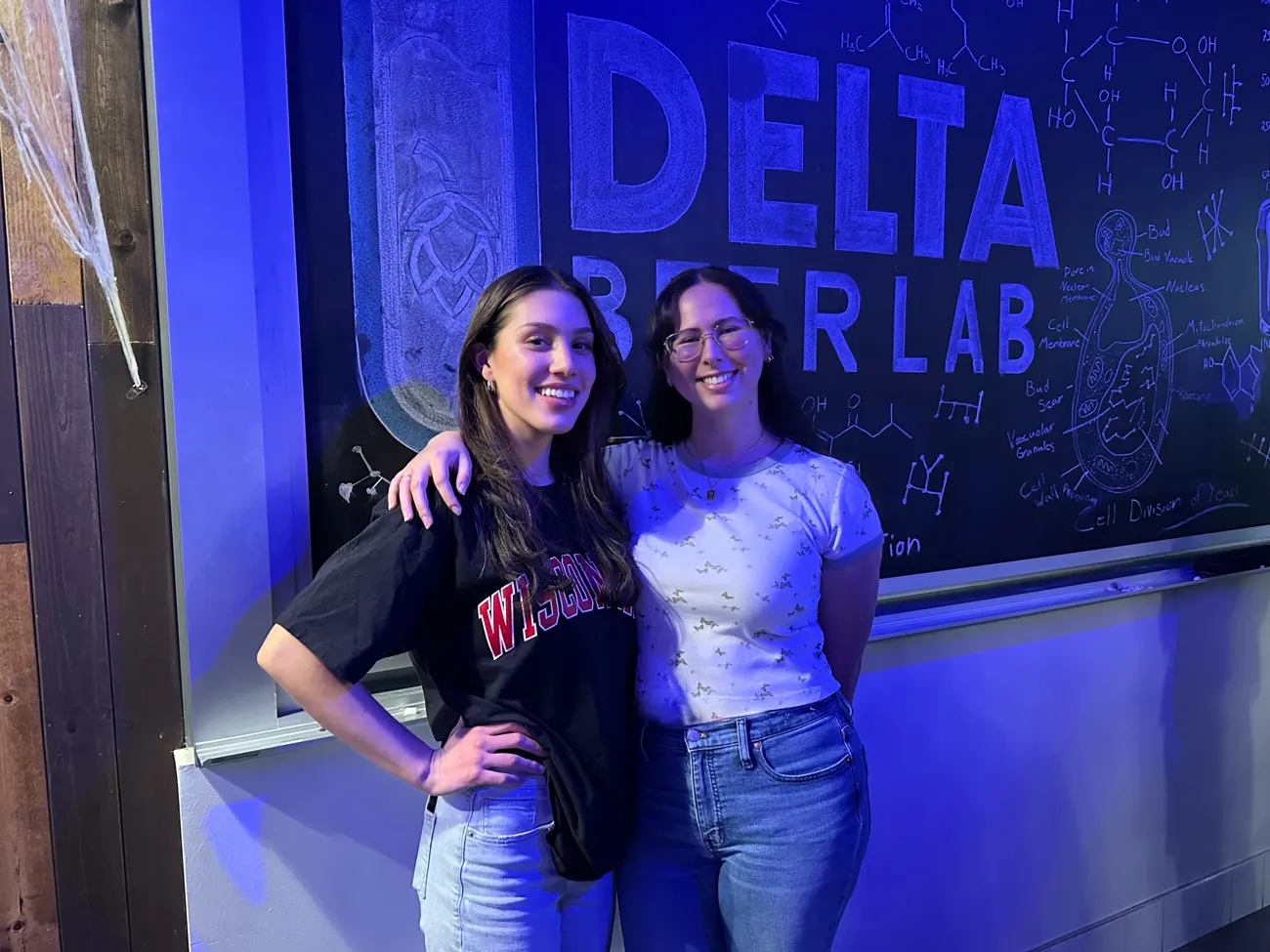 Two attendees posing together inside Delta Beer Lab