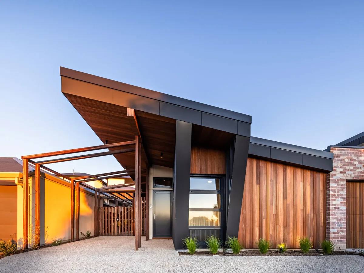 Street front of the 10-star home in Woodforde, Adelaide: a skillion roof with deep eaves, timber batten cladding and a timber pergola over the entry path