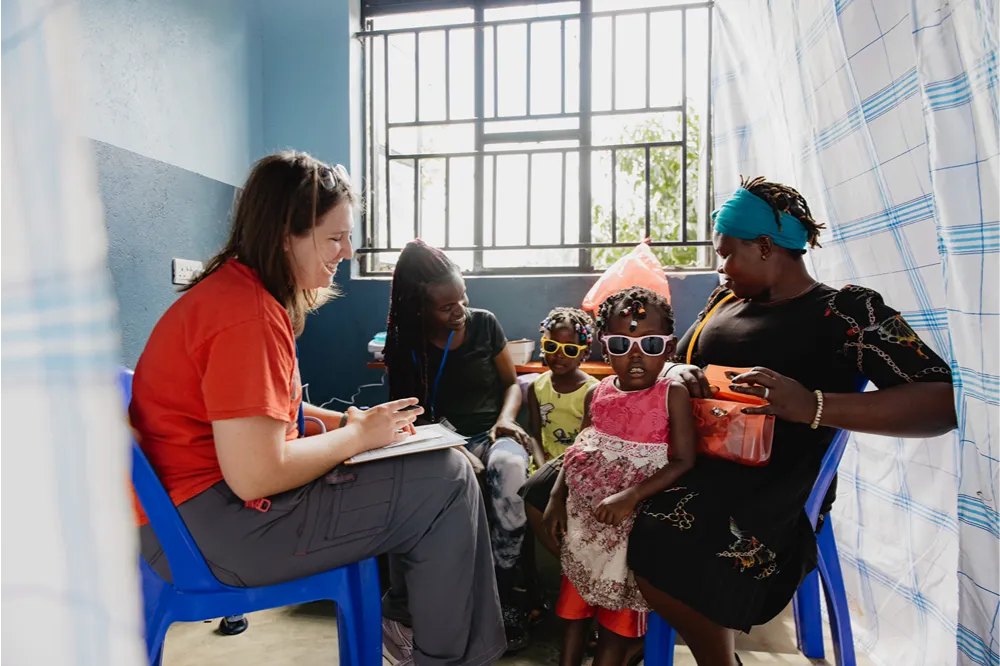 A mission volunteer meets with local mothers and children during an overseas outreach