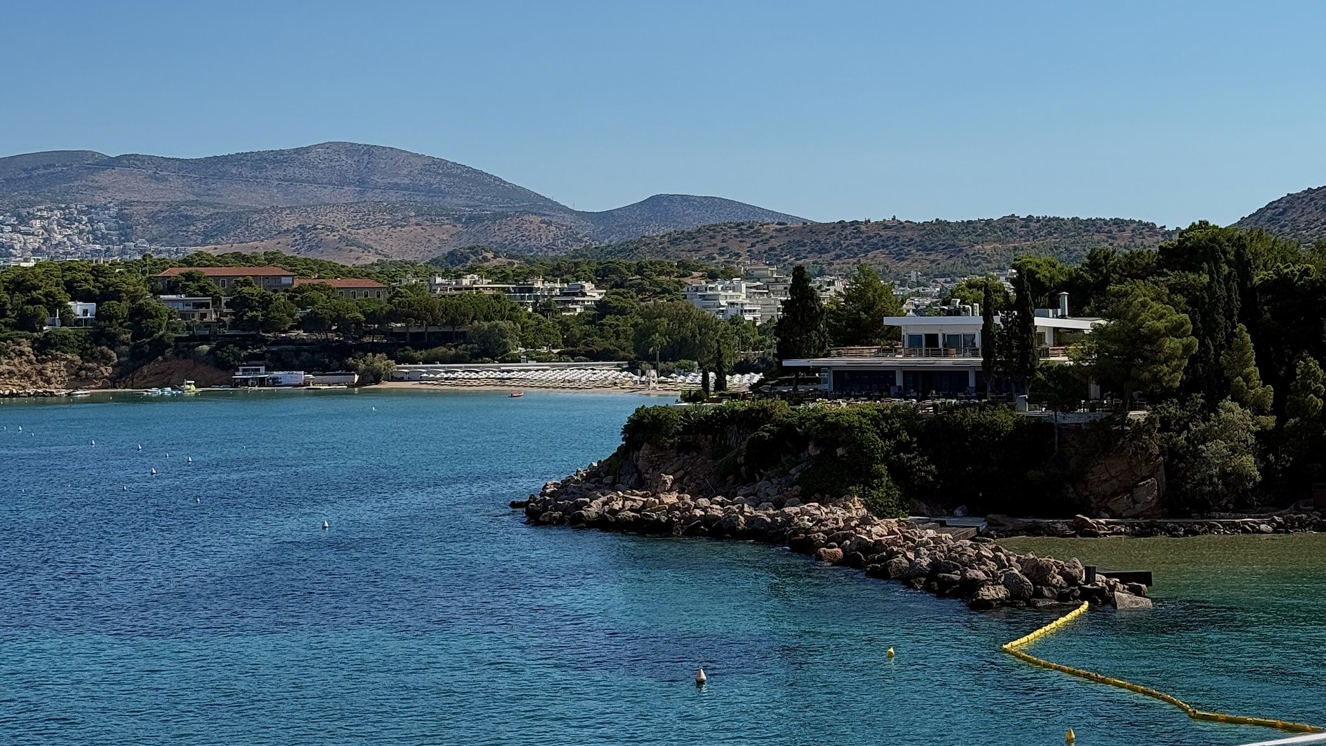 A pine-covered point and clear blue water on the Athens Riviera near Vouliagmeni