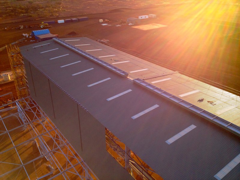 Aerial view of a large industrial shed roof with ridge capping at a remote mining site at sunset