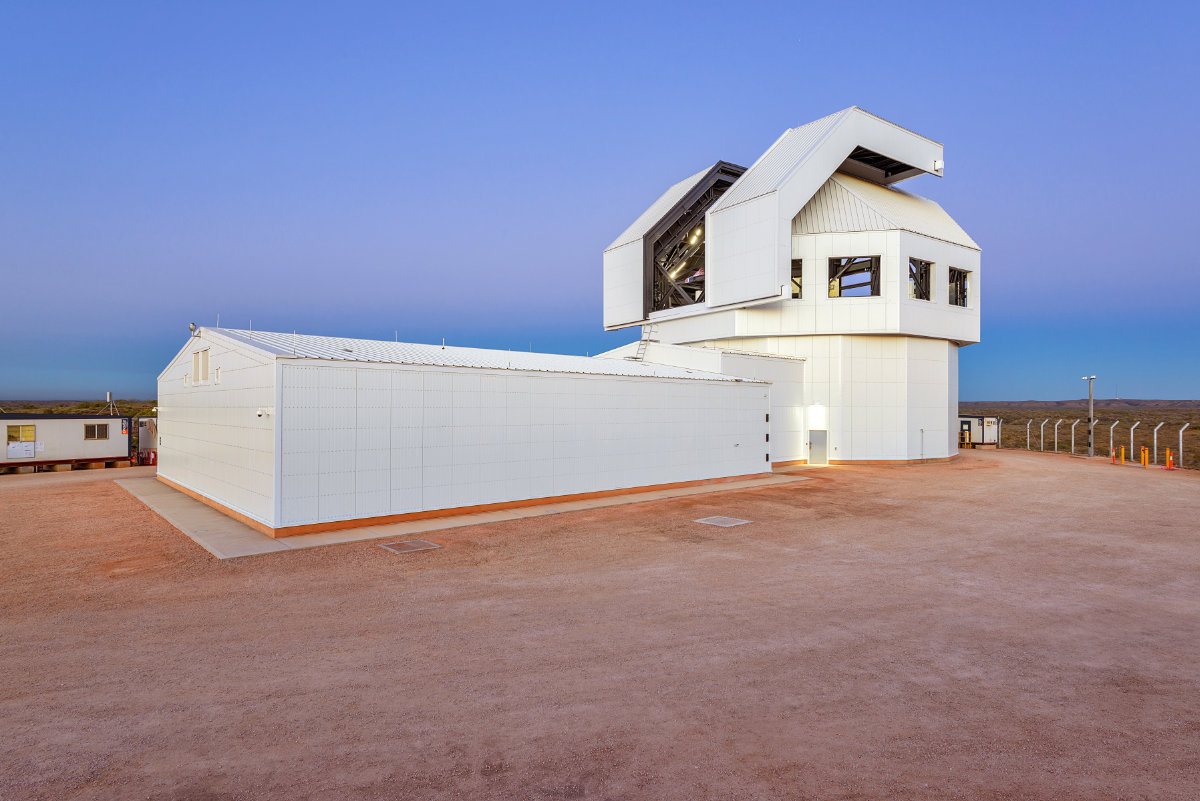 White specialised building with angular roof structure in a remote outback setting at dusk