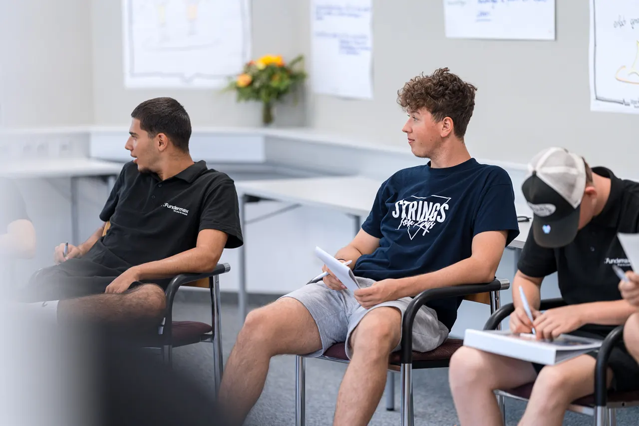 Lehrlinge sitzen bei Lehrlingsseminar und hören gespannt den anderen Teilnehmern zu.