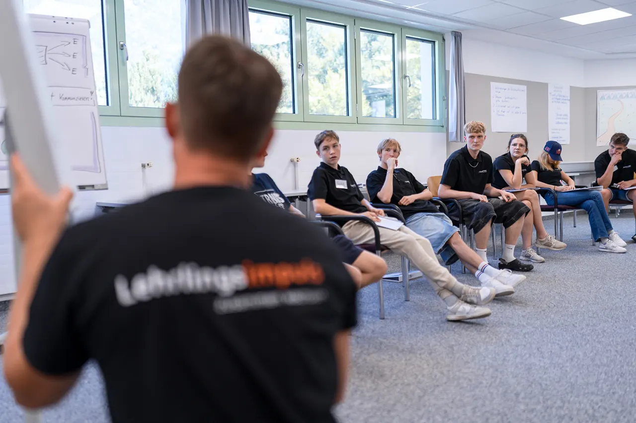 Lehrlinge beim Lehrlingsseminar von Lehrlingsimpuls – aufmerksames Zuhören und gemeinsame Reflexion im Plenum fördern Kommunikation und Gruppendynamik.