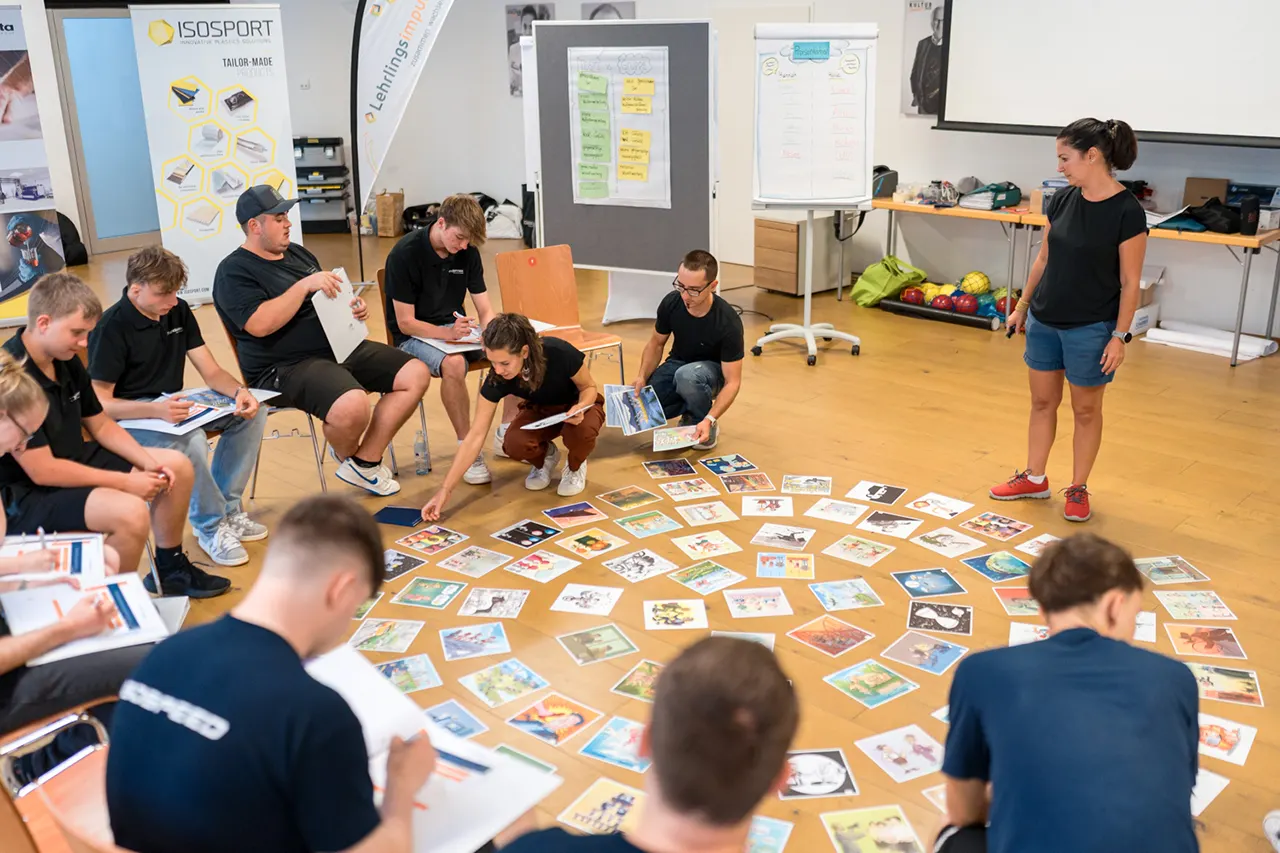 Lehrlinge beim interaktiven Lehrlingsseminar von Lehrlingsimpuls – Gruppenübung mit Bildkarten zur Reflexion und Persönlichkeitsentwicklung im Seminarraum.