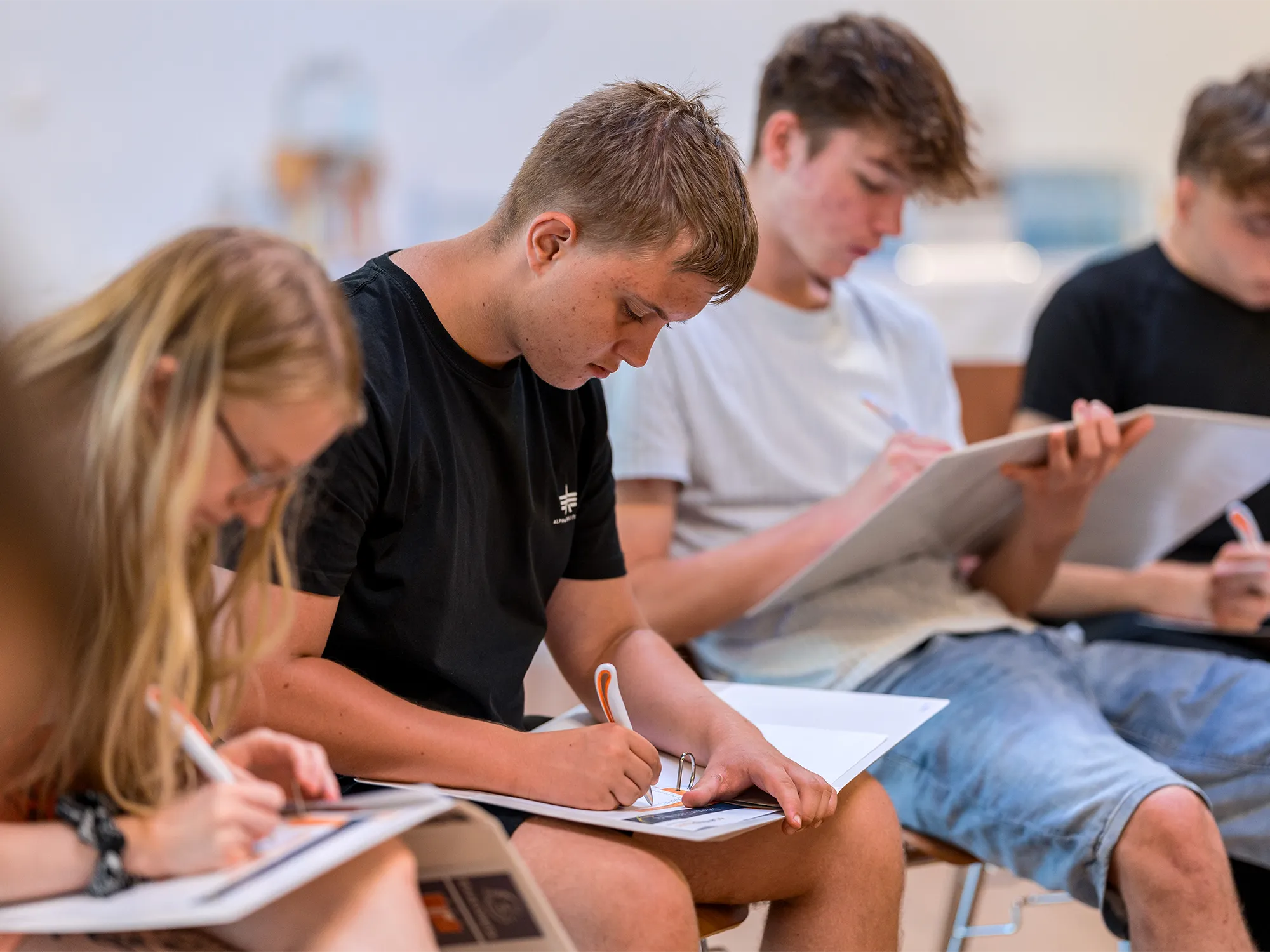 Lehrlinge wie diese im Rahmen eines geförderten Lehrlingstrainings zur Weiterbildung für Lehrlinge den Fragebogen zur Selbstreflexion ausfüllen.