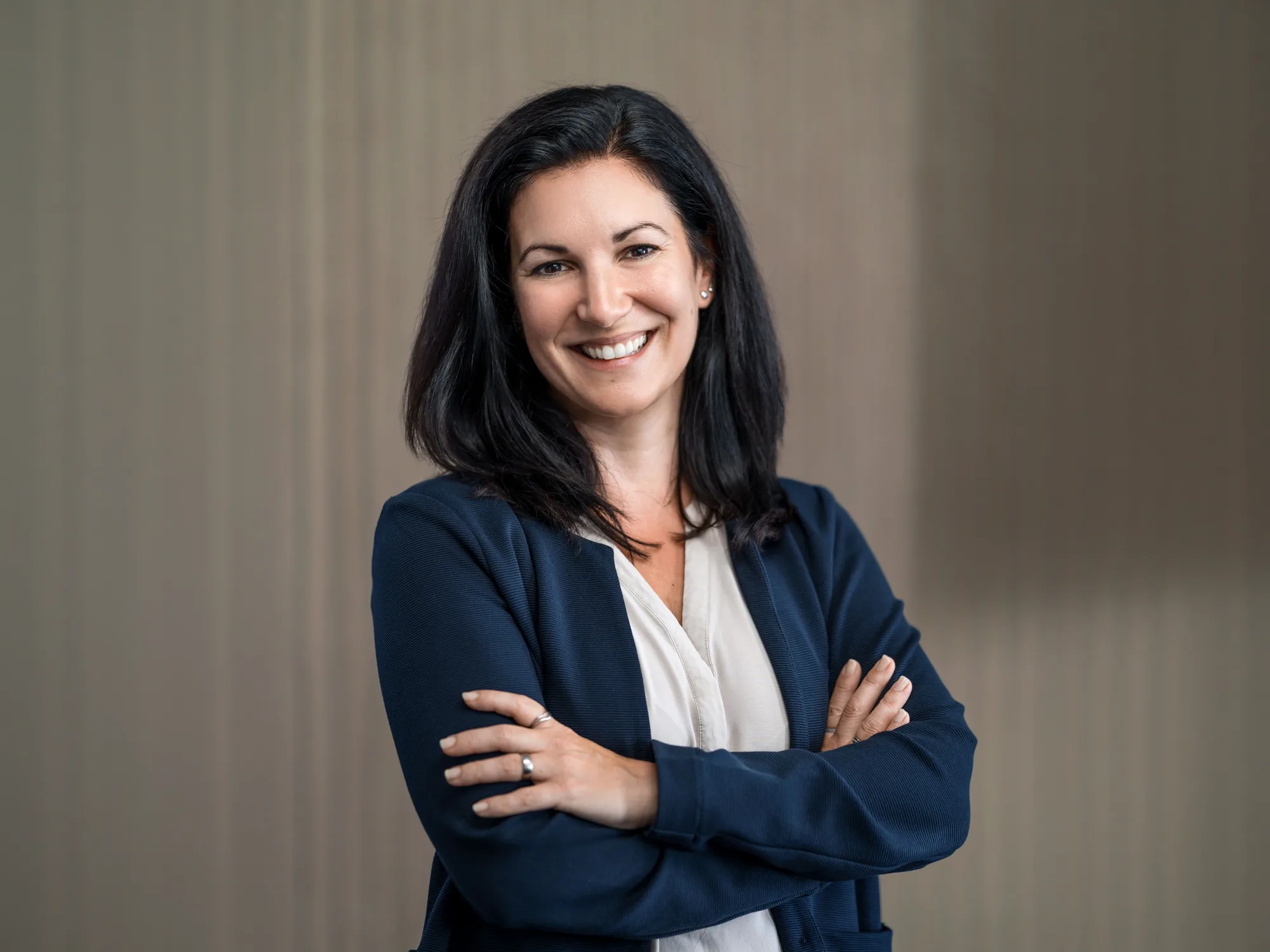 Porträt von Heike Dormuth, Gründerin und Geschäftsführerin von Lehrlingsimpuls, im dunkelblauen Blazer mit verschränkten Armen und einem herzlichen Lächeln.