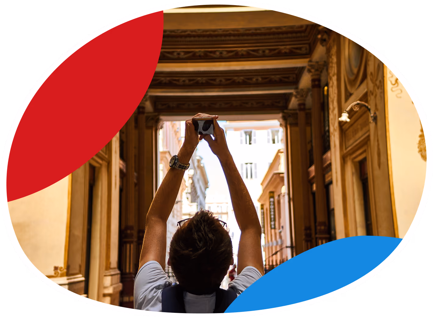Person wearing a backpack, holding up a smartphone to take a photo inside a decorated corridor with ornate columns and arches.