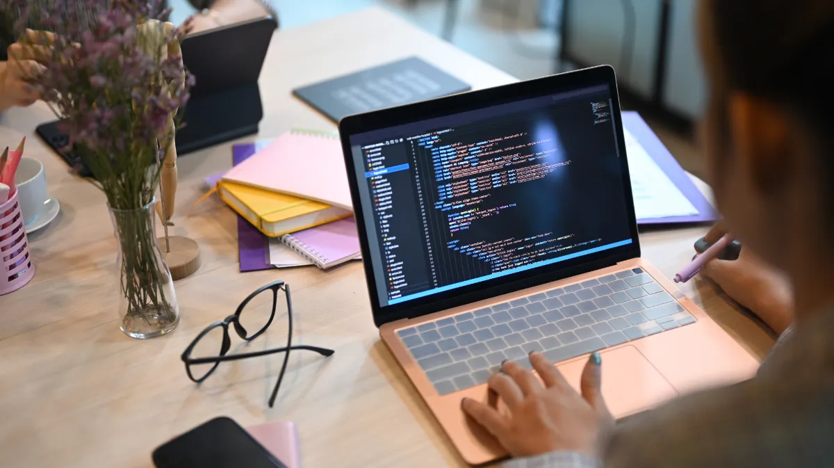Developer writing code on a laptop at a desk