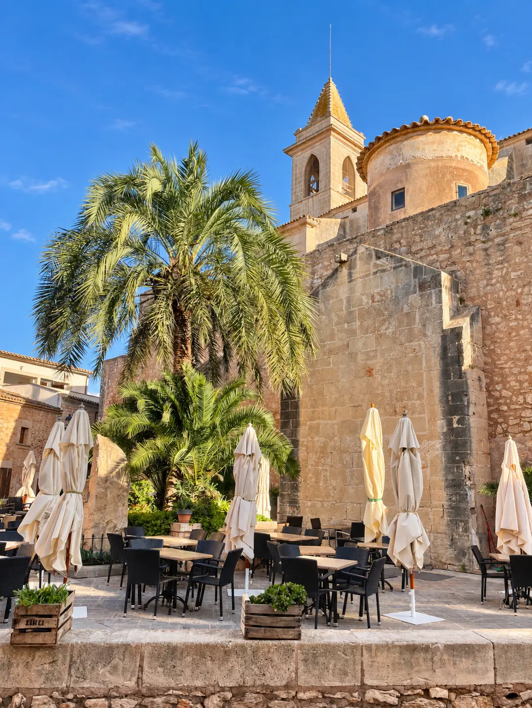 Mallorca area guide Historic stone church and palm-lined square in Santanyí, Mallorca