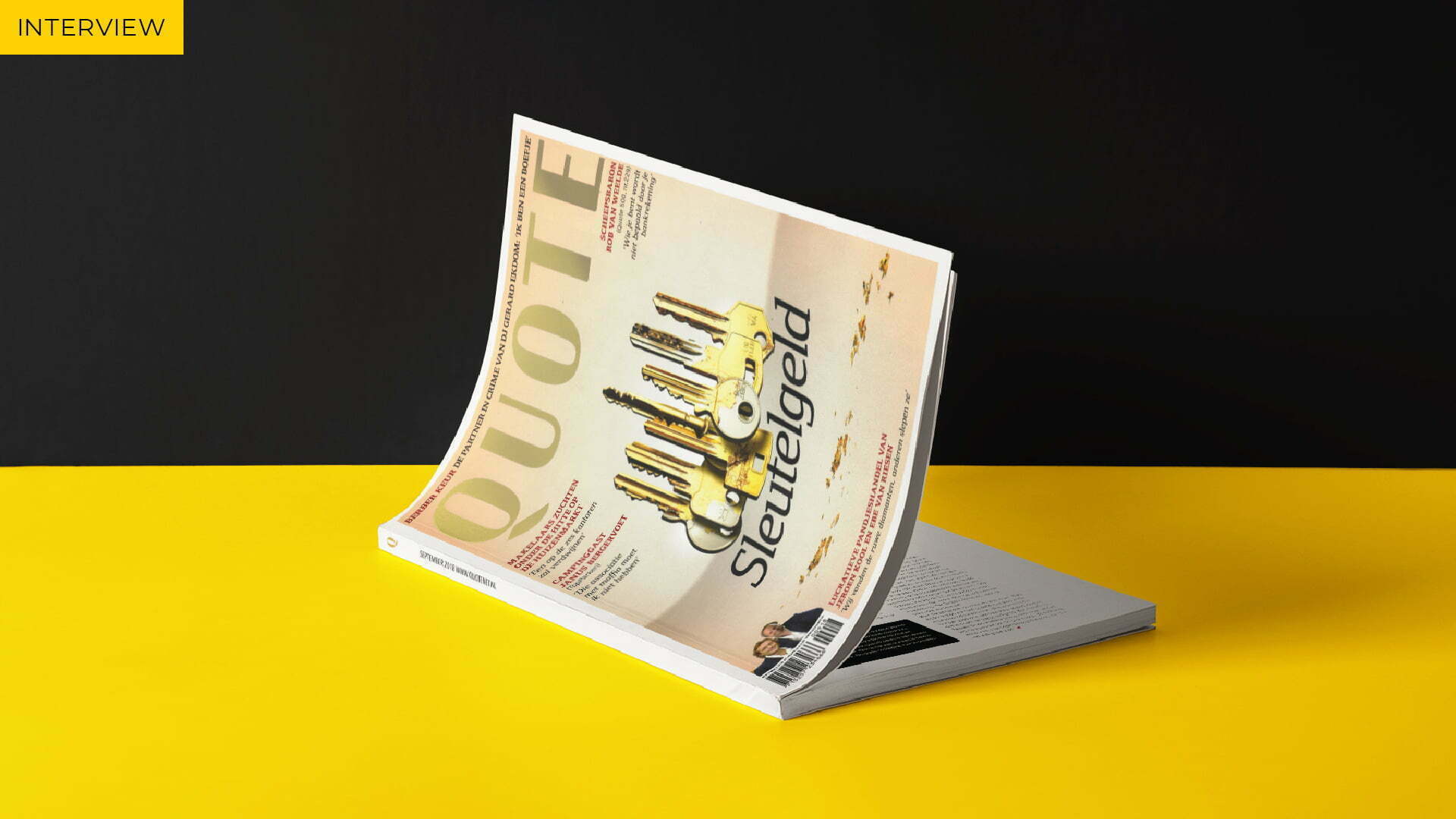 Quote magazine with the cover 'Sleutelgeld' on a yellow table in front of a black wall