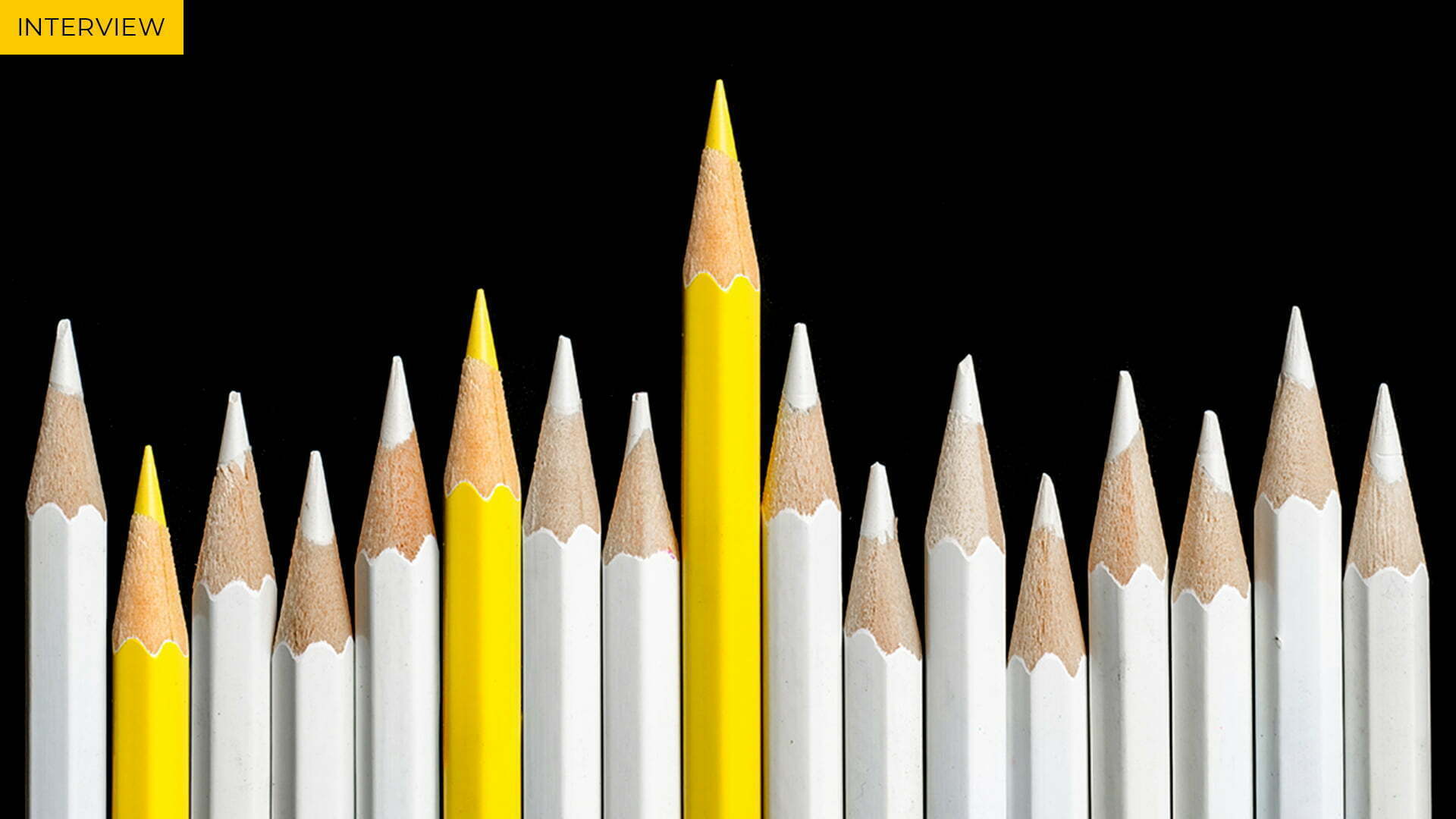 Row of white pencils with three yellow ones, one clearly the tallest, labelled Interview