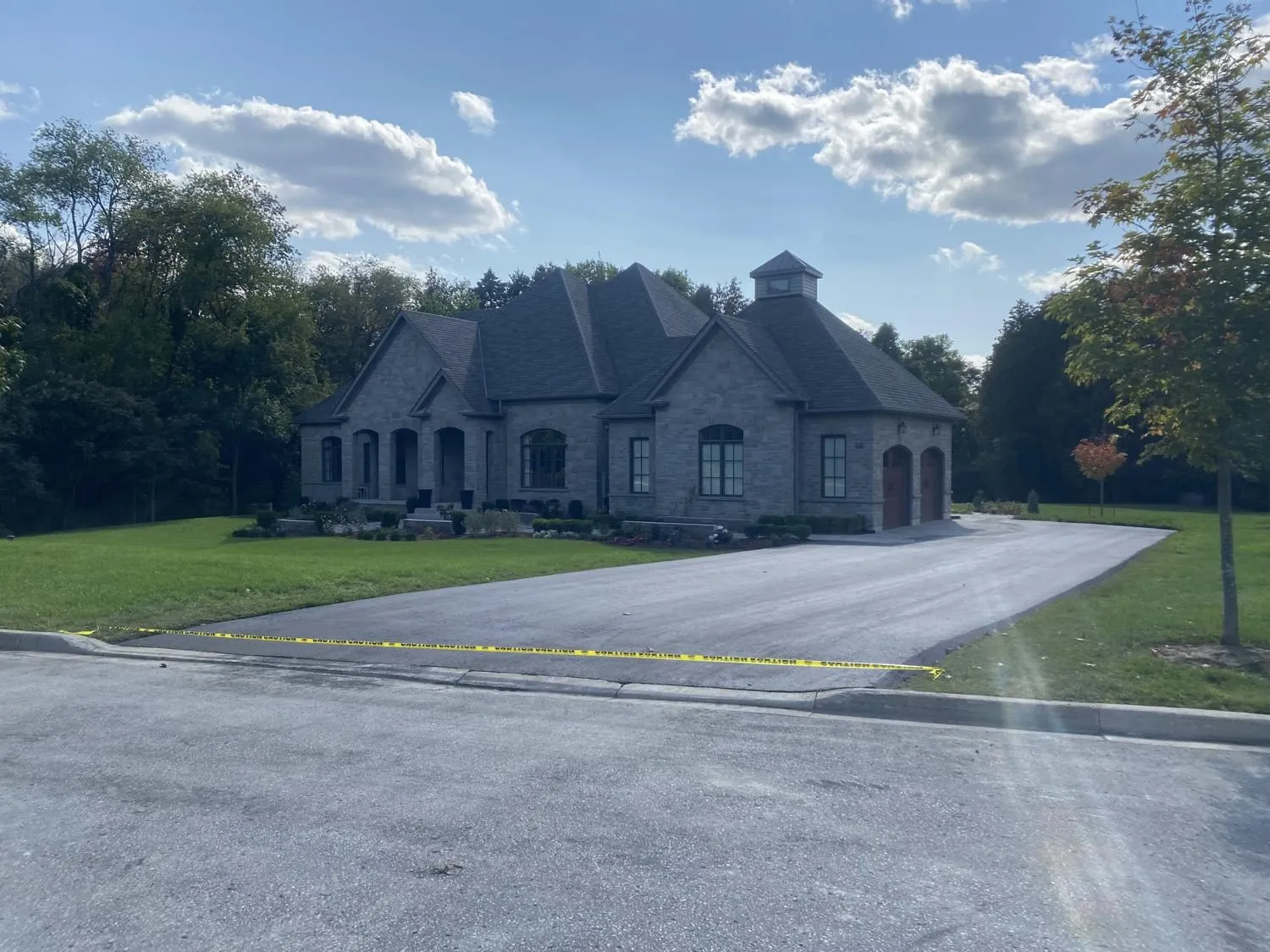 New asphalt driveway at a custom stone home in Durham Region