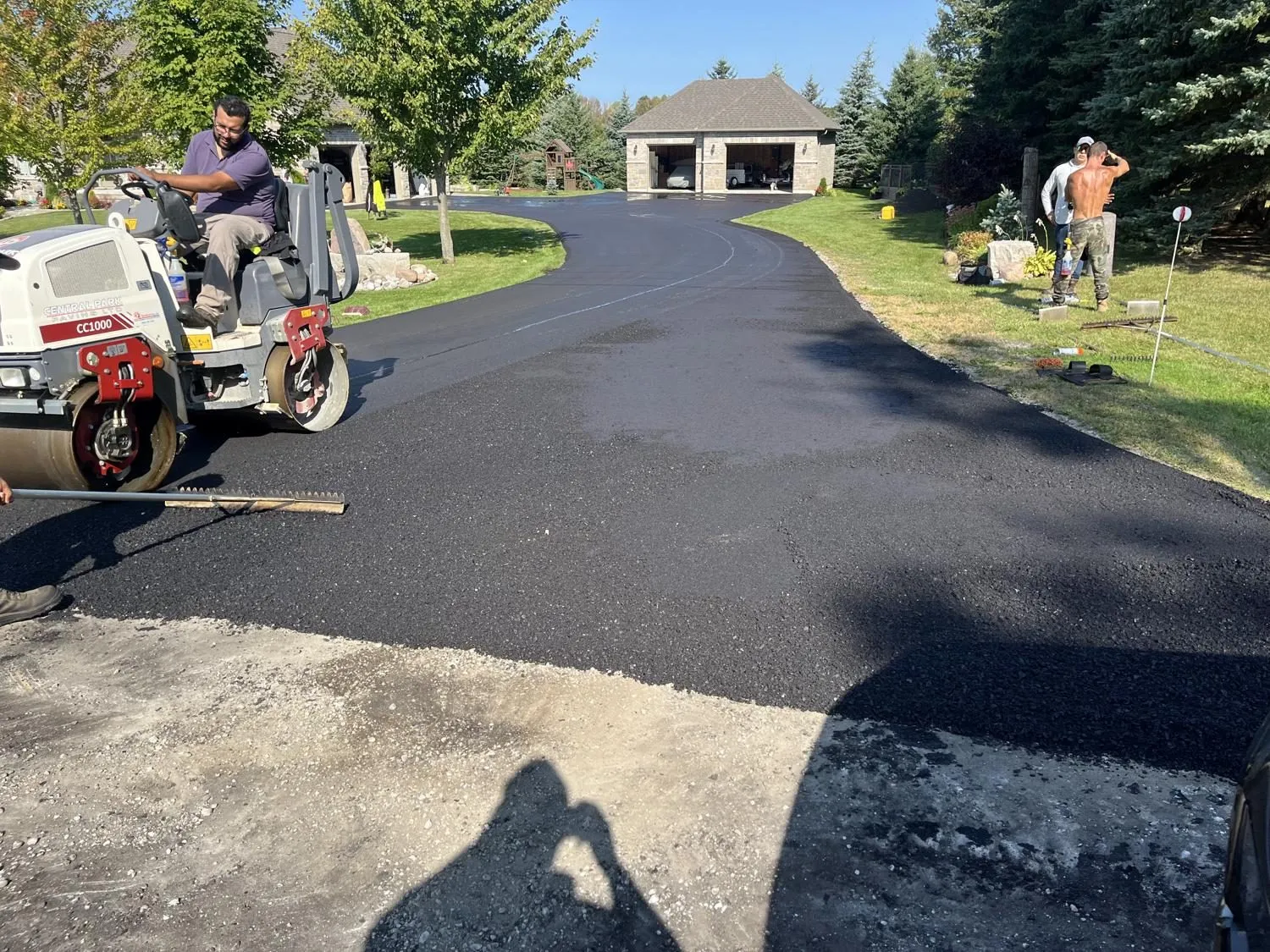 Central Park Paving crew laying and compacting fresh asphalt