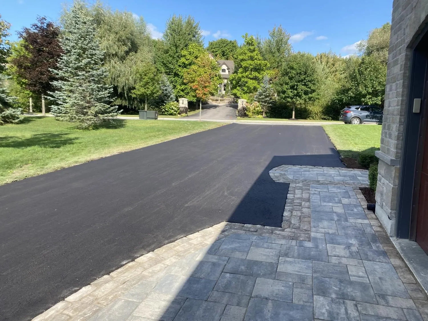 Fresh asphalt paved in a clean transition against an interlock walkway