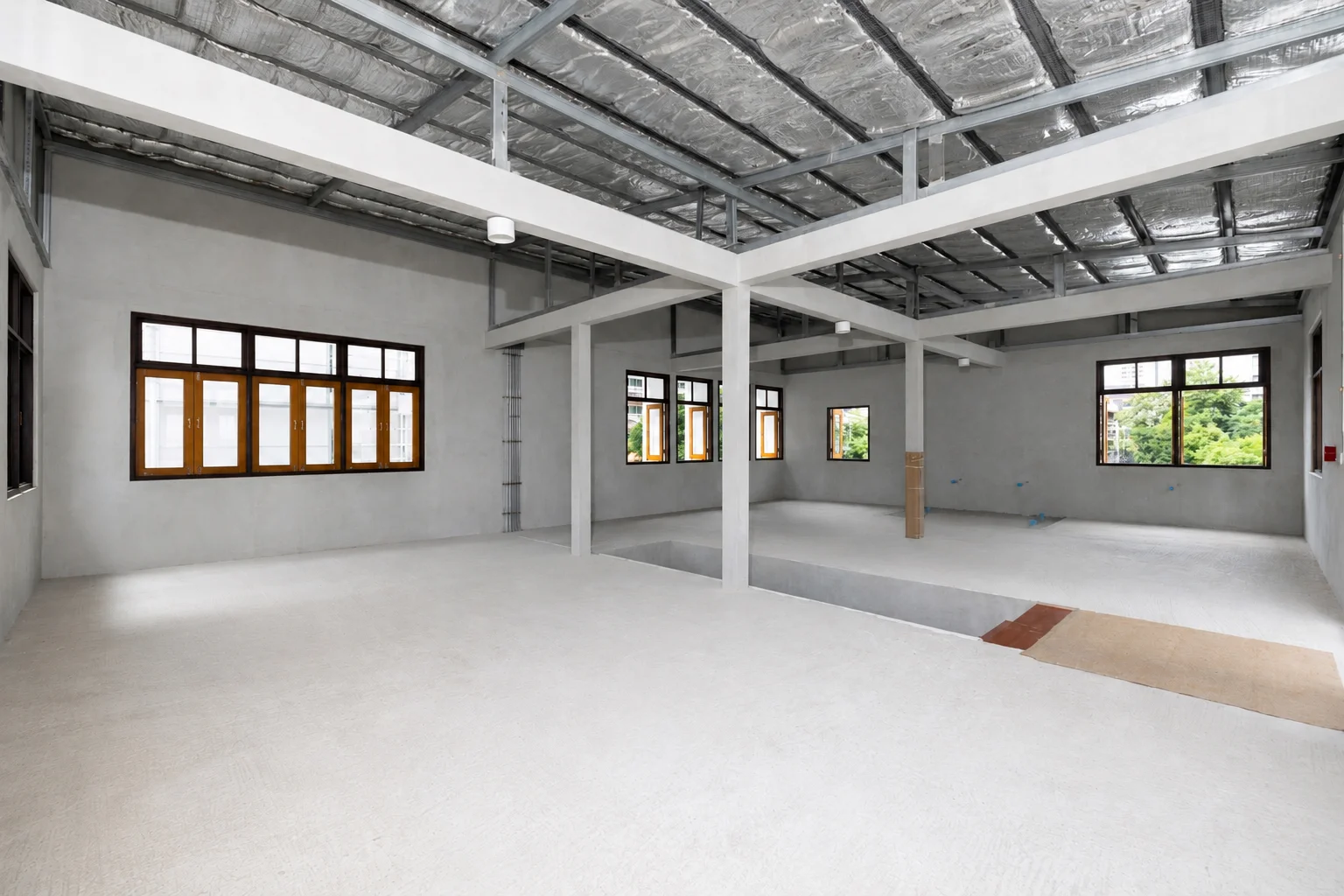 Bare-shell interior of an available unit, concrete and exposed beams