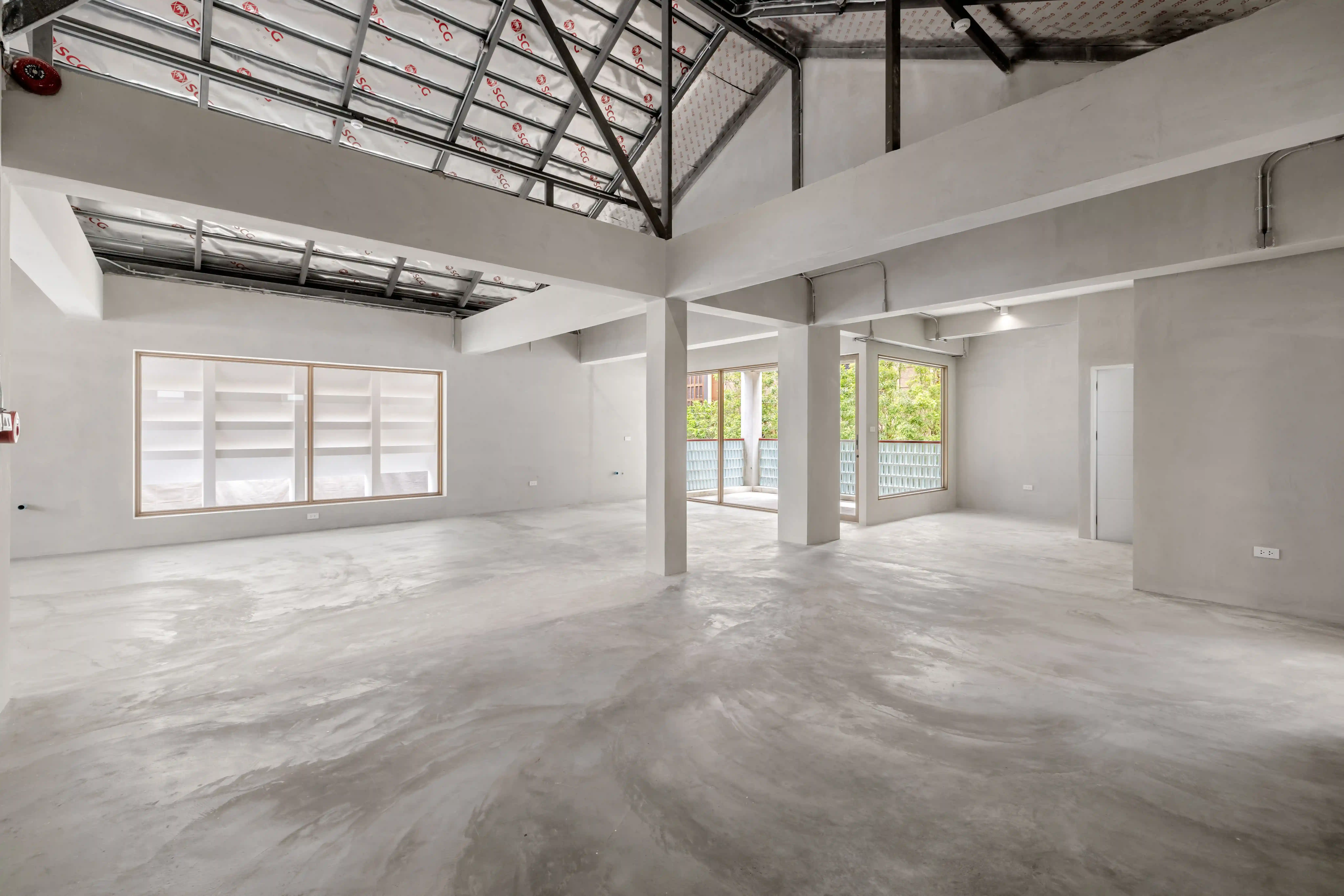 Bare-shell interior of an available unit, concrete and exposed beams