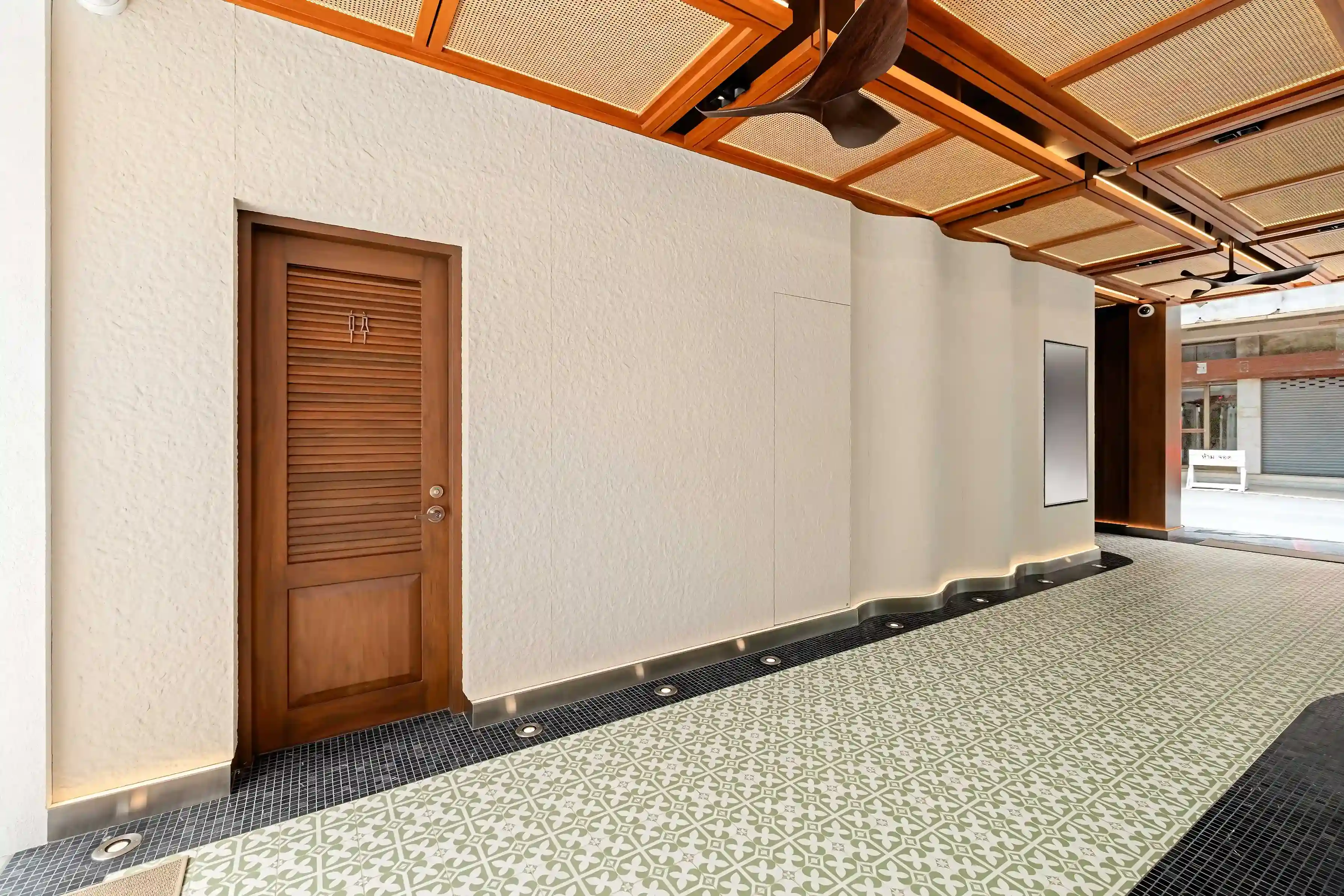 Covered passageway interior, patterned tile floor and rattan ceiling