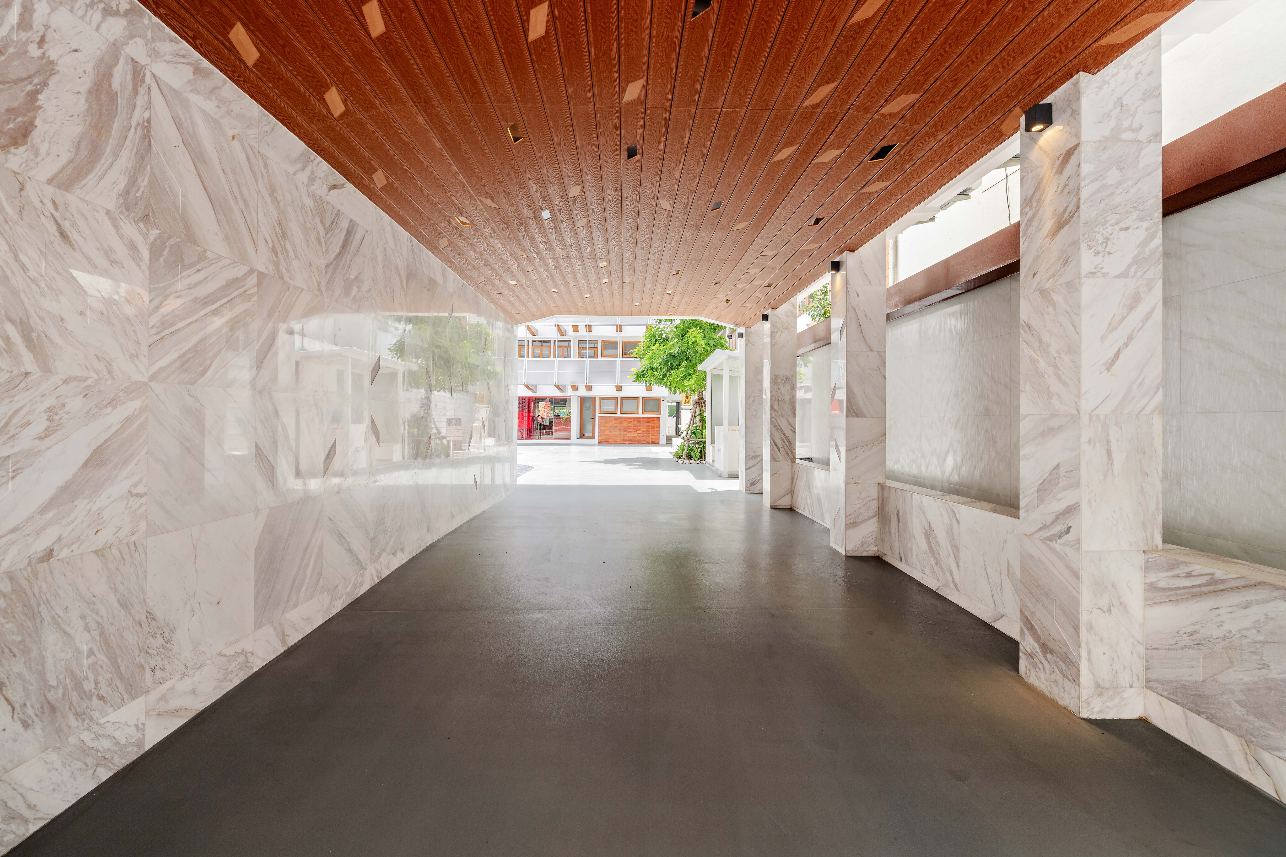 The entrance passage today, marble walls, timber ceiling and a water wall, opening to the courtyard