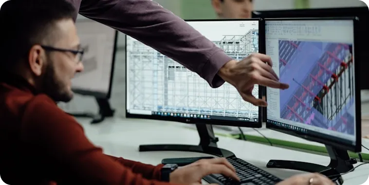 BIM-фахівці працюють із цифровою моделлю будівлі на моніторах