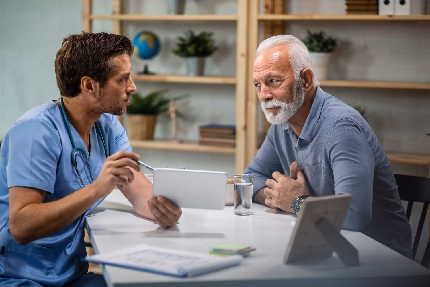 A clinician reviewing preoperative test results with an older patient on a tablet