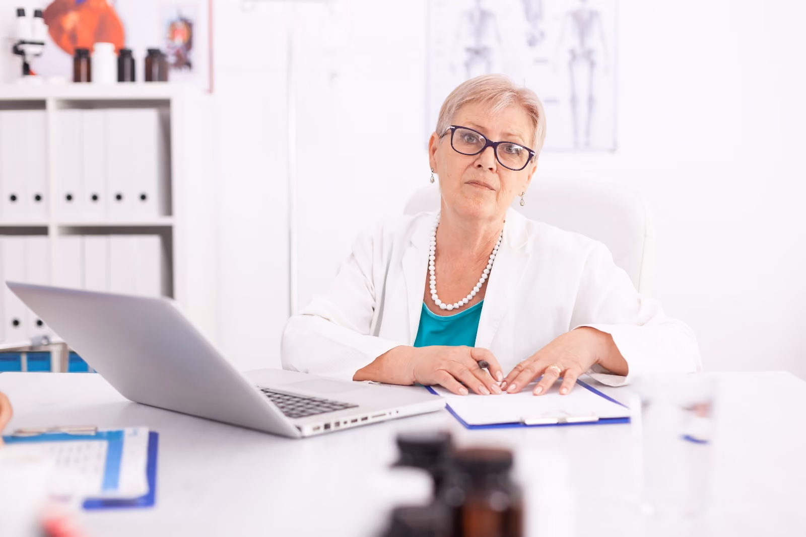 A consultant anaesthetist reading preoperative guidance at a clinic desk