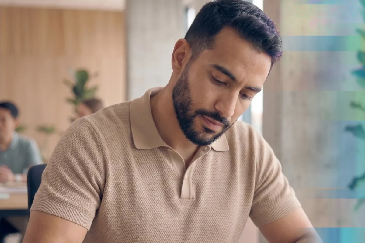 A man looking down in concentration while working at a desk