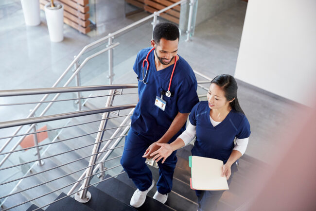 Two medical assistants walking together on a staircase