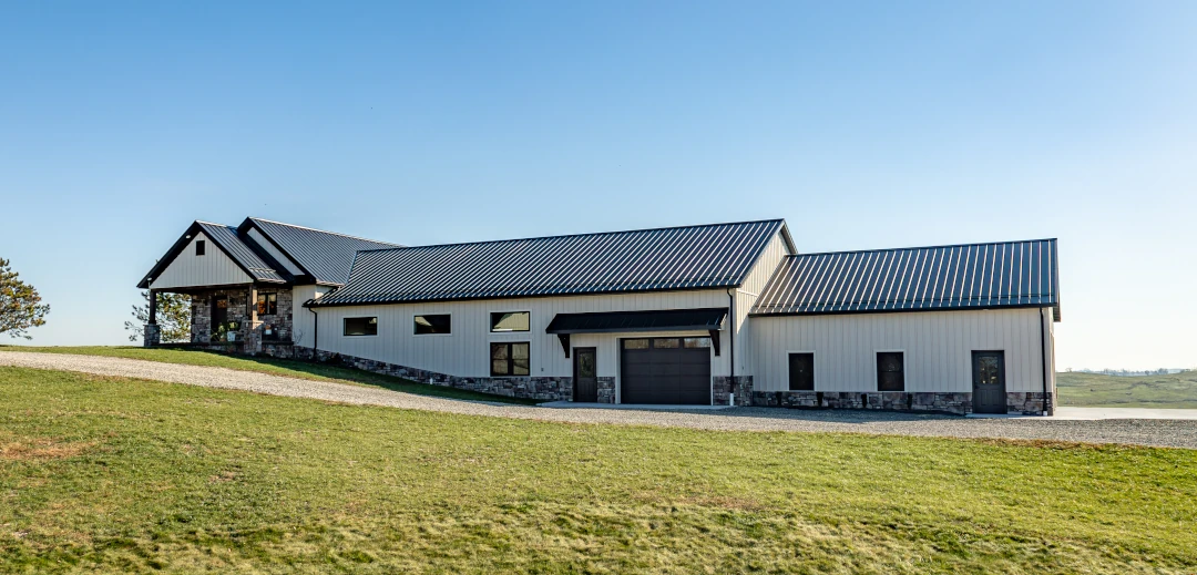 long modern home with white siding and metal roof