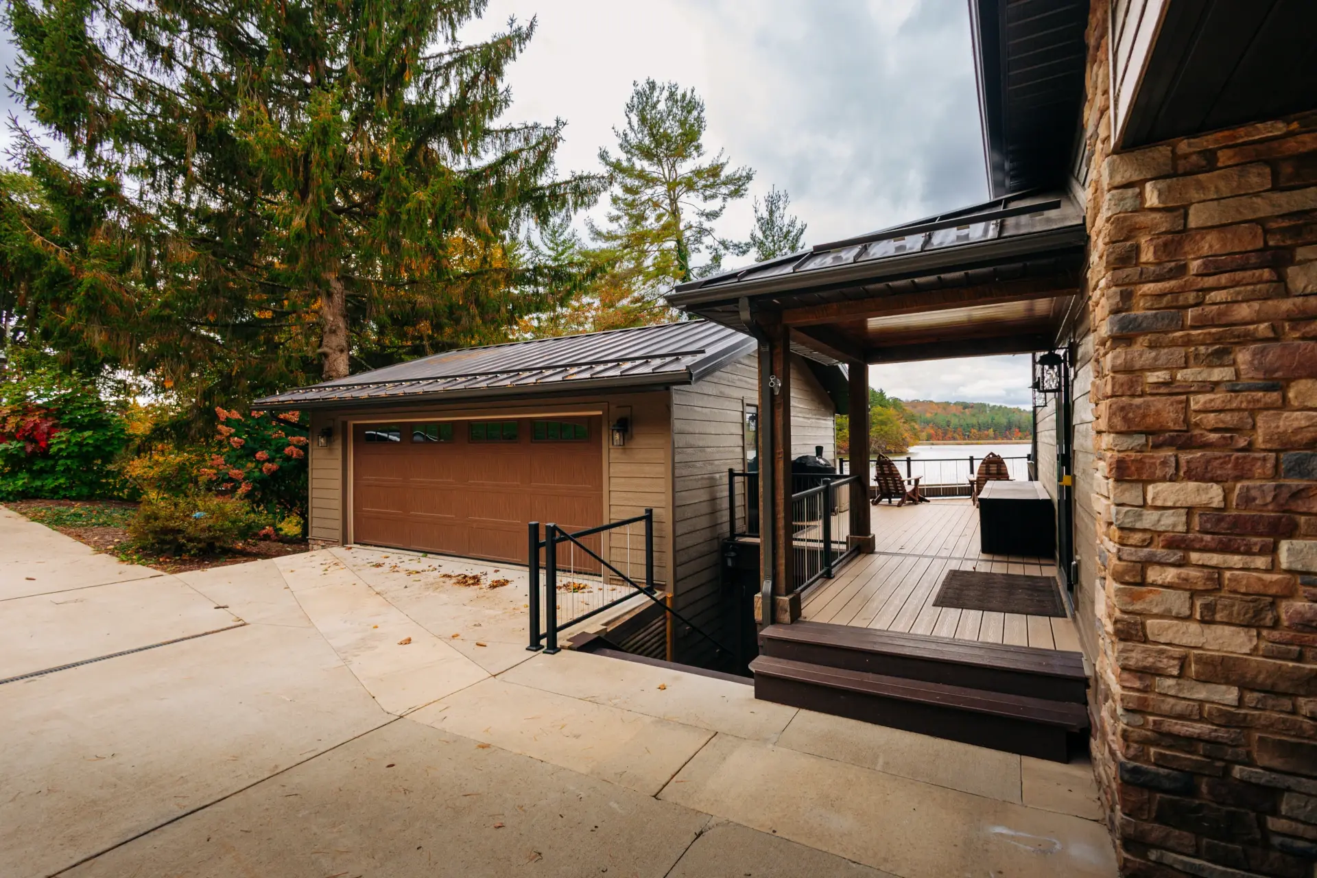 detattched garage with deck connecting house and lake in background