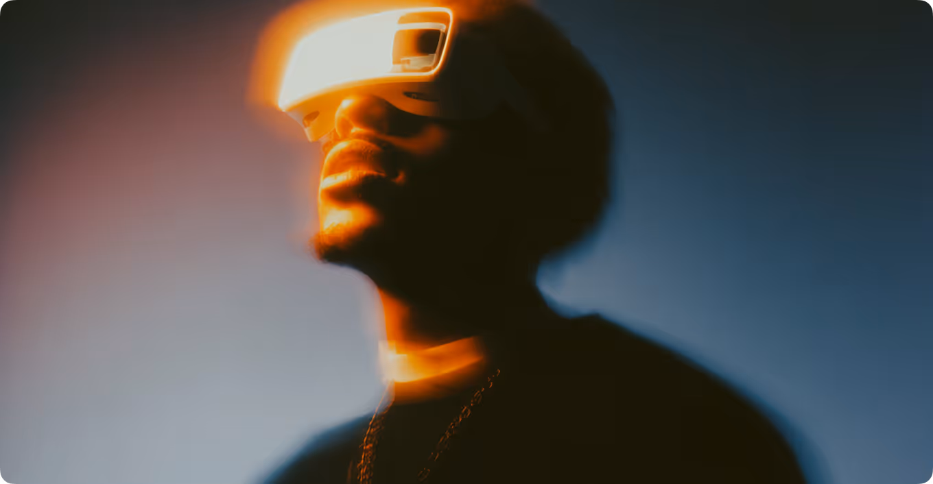 Person wearing virtual reality headset glowing with orange light against a dark blue background.