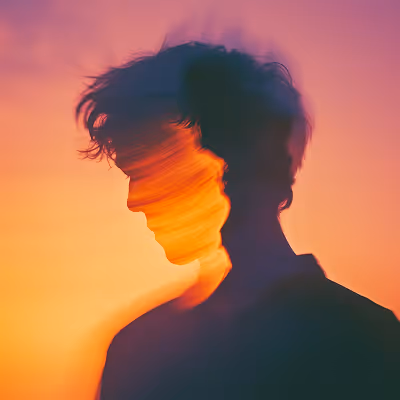Double exposure of a person’s silhouette with blurred motion at sunset in warm colors.