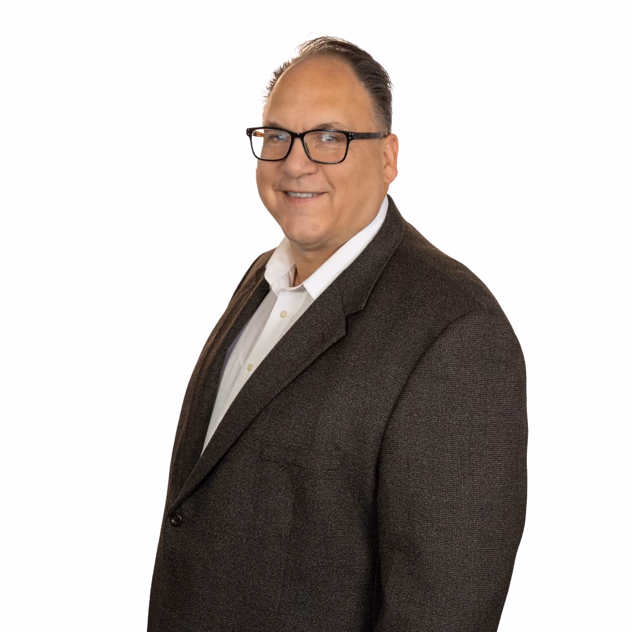 Smiling man wearing glasses, a white shirt, and a brown blazer on white background.