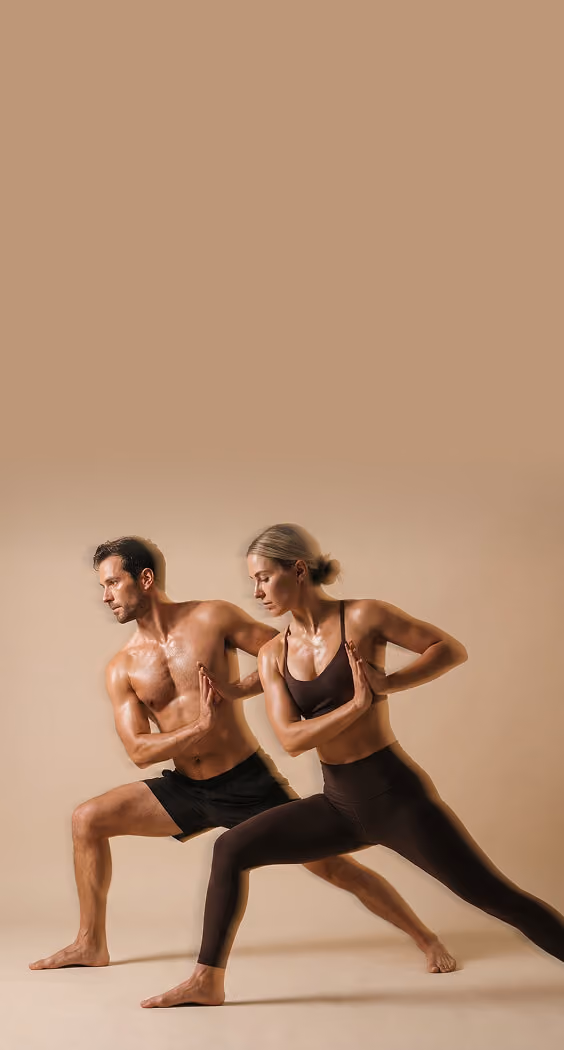 A fit man and woman in athletic wear perform a yoga twist pose side by side against a neutral beige background.