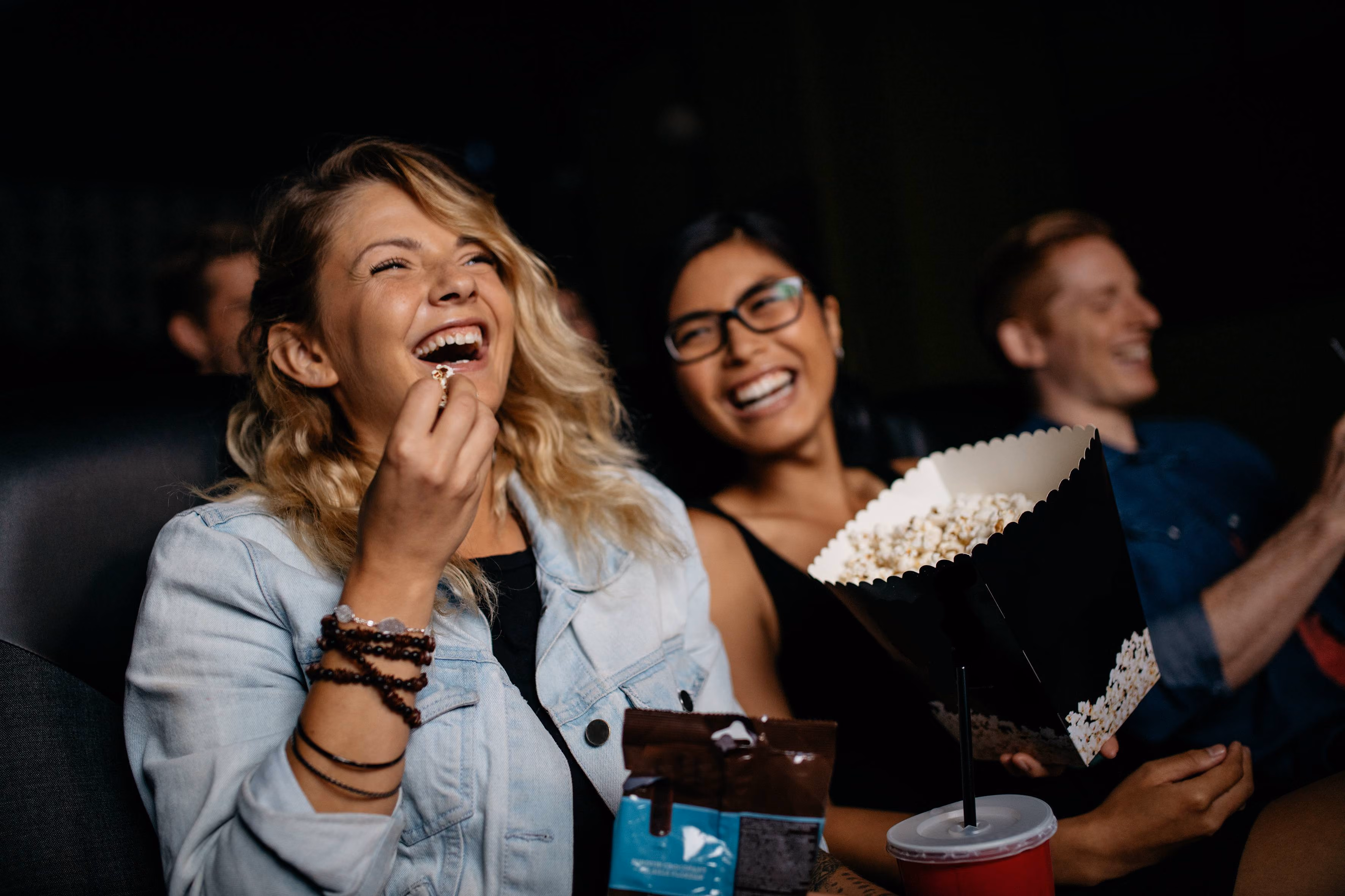 Two people at movie theatre eating popcorn stock image