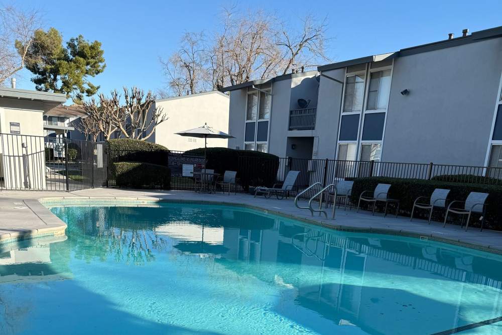 Pool with apartment building behind it