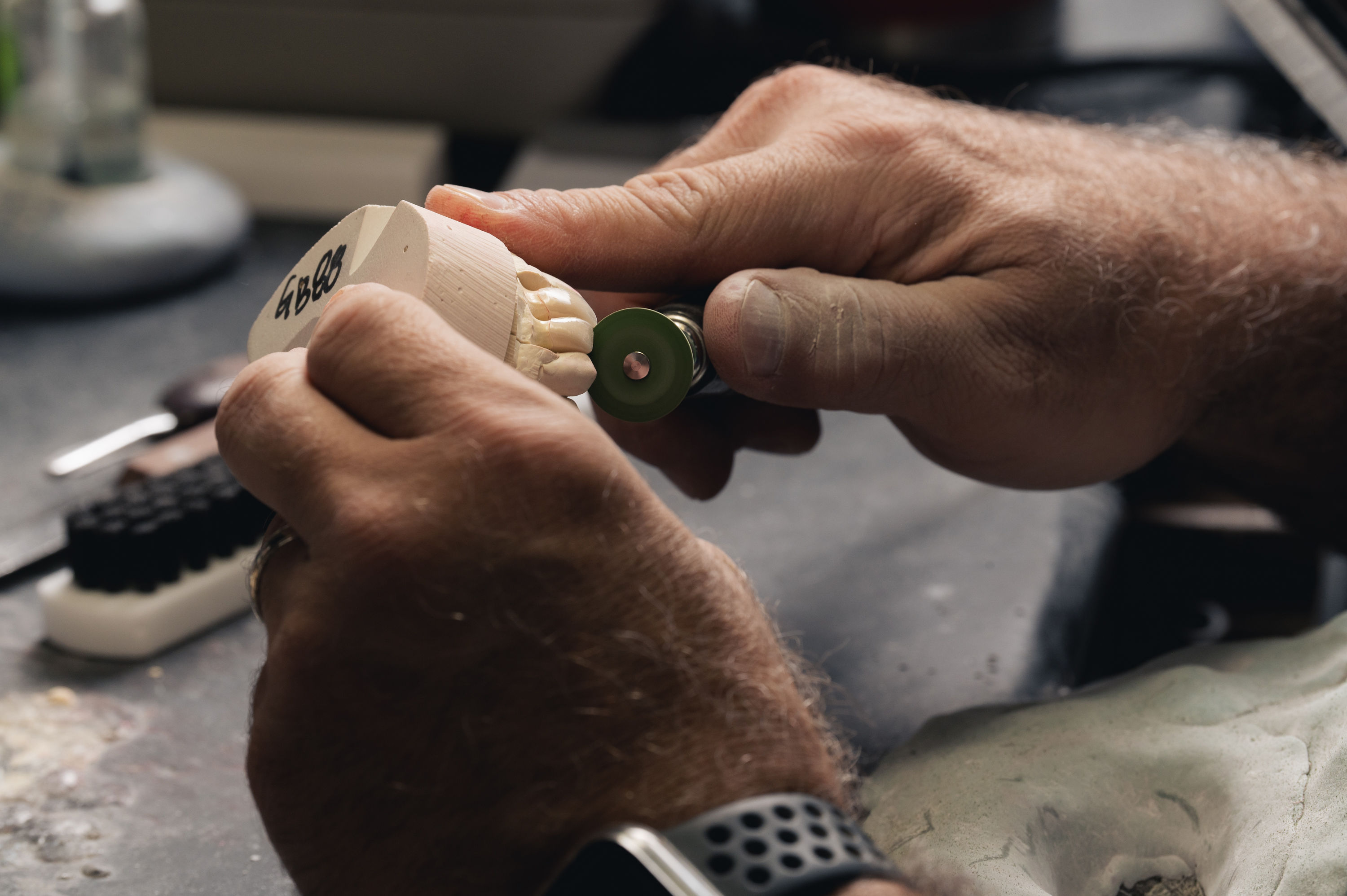 Dental technician hand-finishing a restoration on a model at Gibson Dental Designs