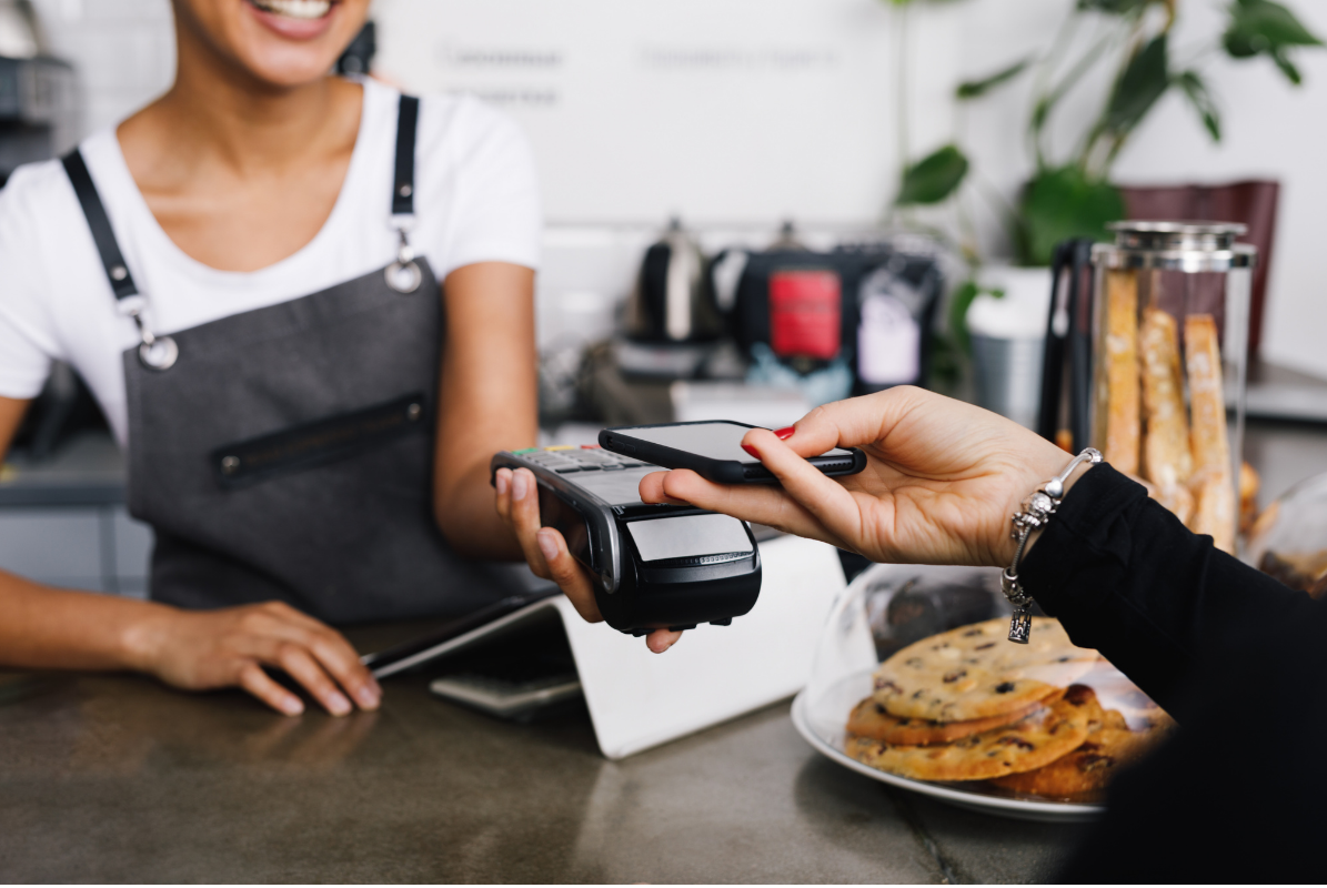 Customer tapping to pay at a cafe counter