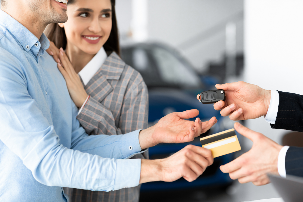 Customer receiving car keys at a dealership desk