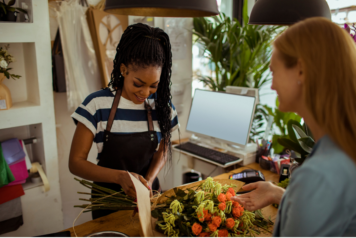 Florist serving a customer at a shop counter
