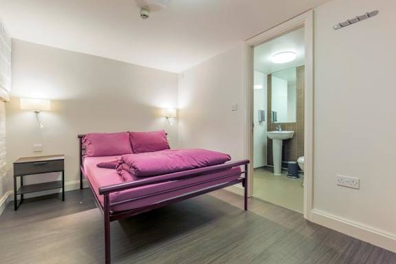 Private room with bed and bathroom doorway