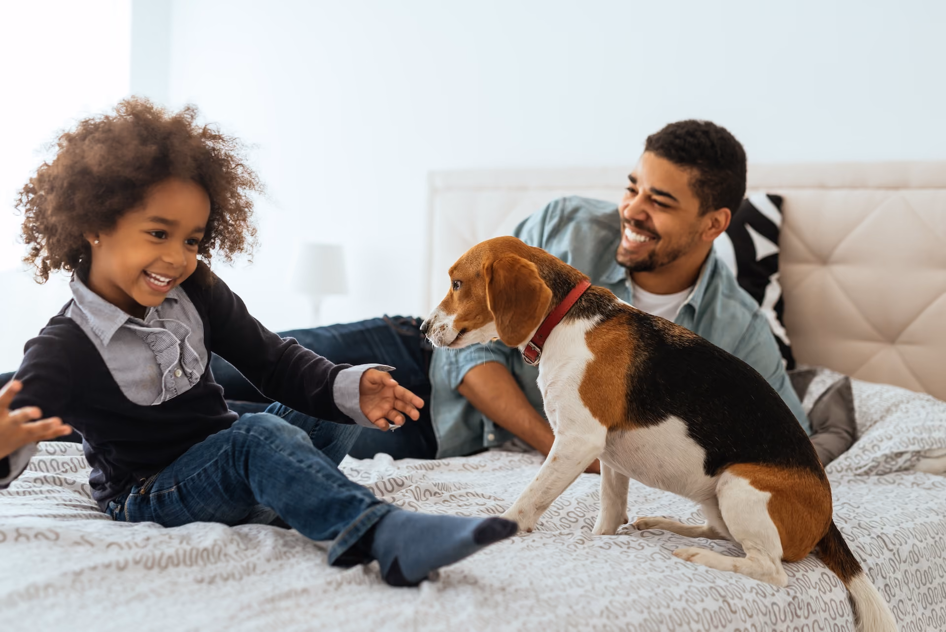 Father and child on bed with dog