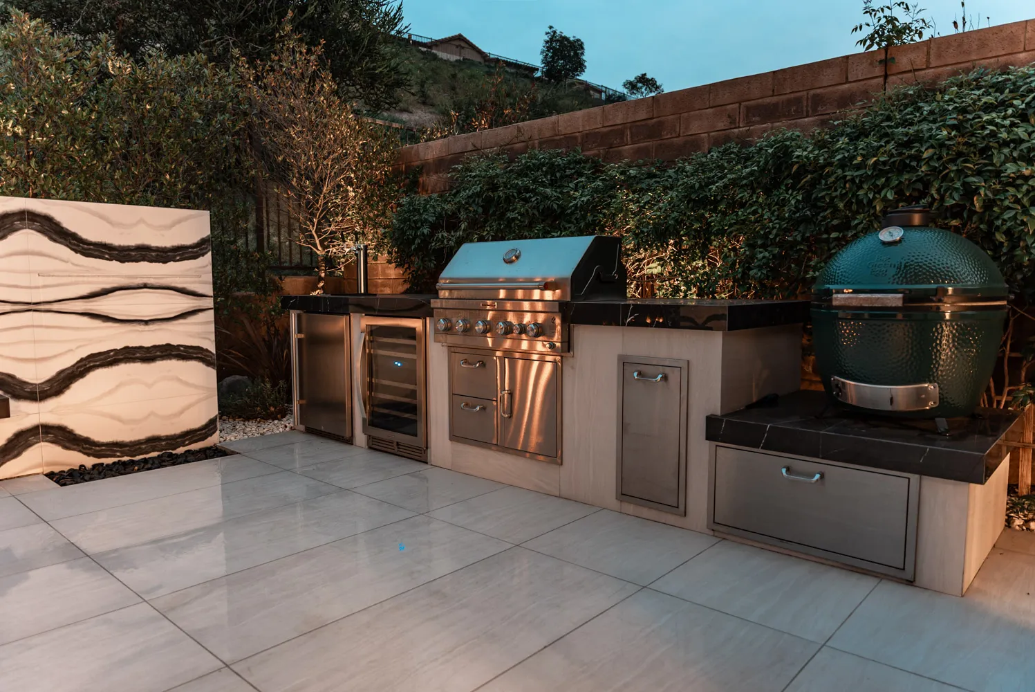 The kitchen run seen wide, the figured marble wall standing at its near end.